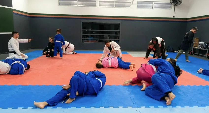 Aula no tatame da Fator Dojo, com alunos treinando em duplas